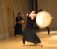Catrina in rehearsal beating a drum