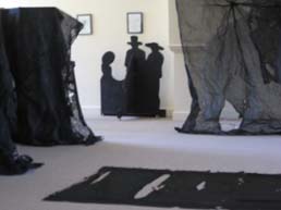 Focus on black silhouettes behind the scrim