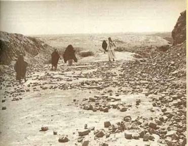 Figures walking in a rocky desert landscape